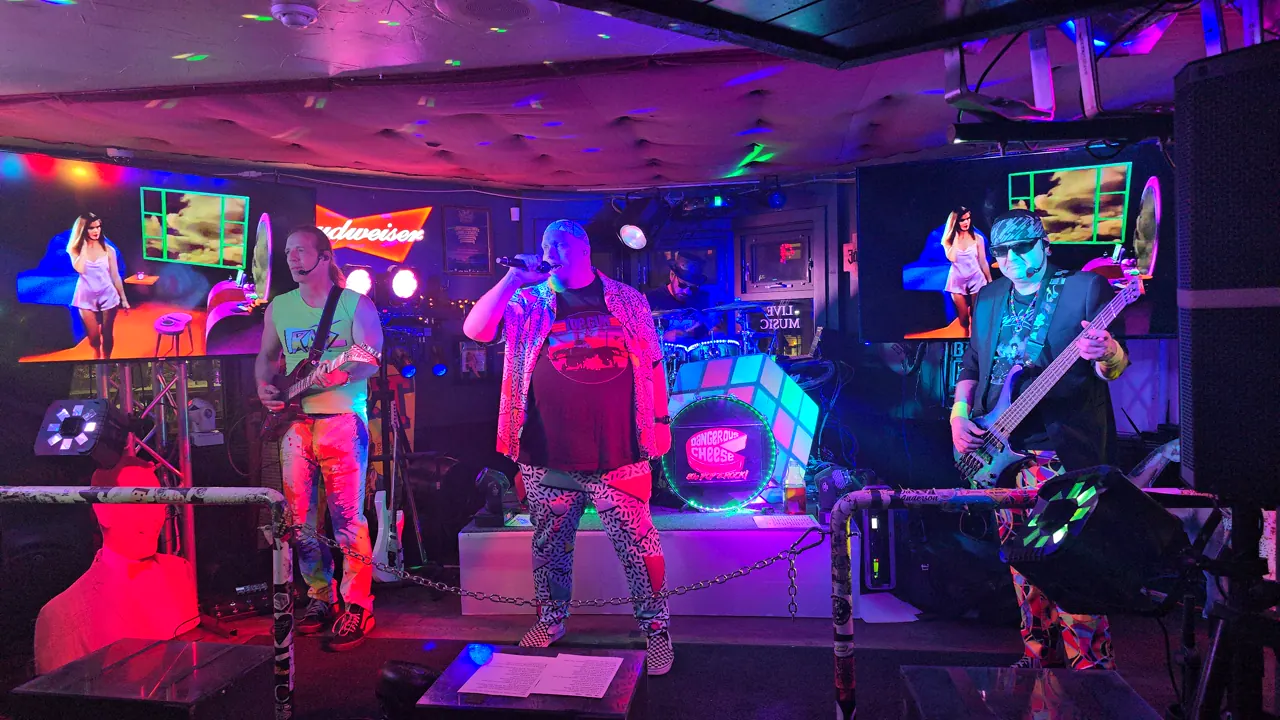 Dangerous Cheese performing under vivid neon stage lighting in Banff in 2024